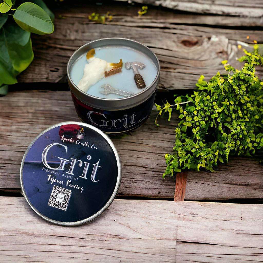 Grit inspired candle with a cow head and hammer embed in light blue soy wax in a tin candle container