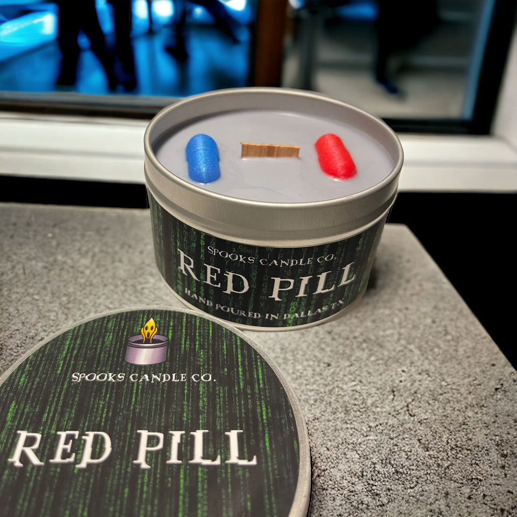 The Matrix inspired candle with a red and blue pill in a dark tin candle container